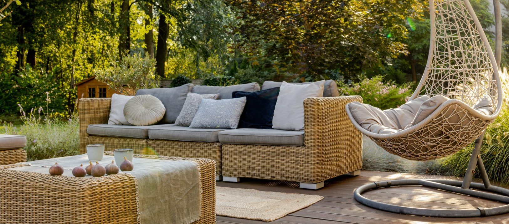 Cozy porch with wooden floor, rattan furniture and hanging chair
